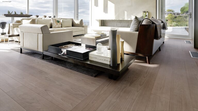 mafi Naturholzboden Buche welcher ein modernes und elegantes Wohnzimmer mit Kamin und Sitzbereich ziert